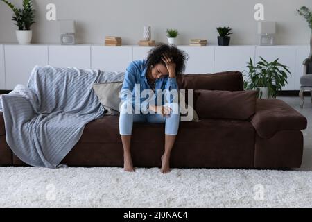 Deprimiert erschöpfte junge afrikanische Frau, die Stress fühlt Stockfoto