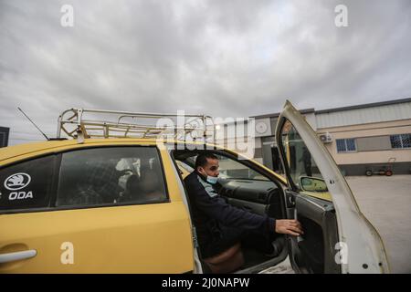 Beit Hanoun, Palästinensische Gebiete. 20. März 2022. Ein Mann fährt mit einem Taxi vor dem Erez Grenzübergang, als palästinensische Arbeiter Beit Hanoun im nördlichen Gazastreifen verlassen, um in Israel zu arbeiten. Israel bereitet sich darauf vor, 2.000 Arbeitsgenehmigungen für die in Gaza lebenden Palästinenser auszustellen, wodurch die Gesamtzahl der Beschäftigten auf israelischer Seite auf 12.000 erhöht wird. Kredit: Mohammed Talatene/dpa/Alamy Live Nachrichten Stockfoto