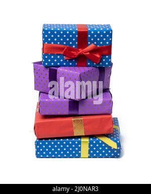 Stapel von Schachteln in Papier gewickelt und mit einem Seidenband auf weißem Hintergrund gebunden, Feier. Geschenkschachtel-Set Stockfoto