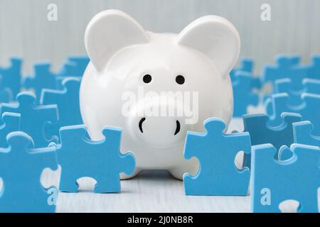 Sparschwein, umgeben von Puzzleteilen Stockfoto