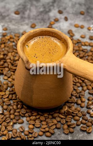 Türkischer Kaffee in einer irdenen Kanne auf dunklem Hintergrund. Nahaufnahme Stockfoto