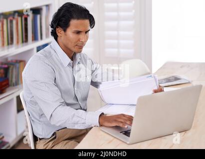 Es ist schwer, aus dem Internet zu bleiben. Beschnittene Seite eines gutaussehenden Geschäftsmanns, der von zu Hause aus arbeitet. Stockfoto