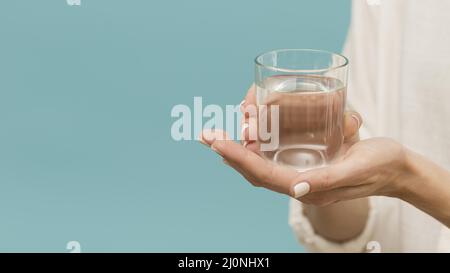 Frau hält mit Wasser gefülltes Glas und kopiert Platz. Hohe Qualität und Auflösung schönes Fotokonzept Stockfoto