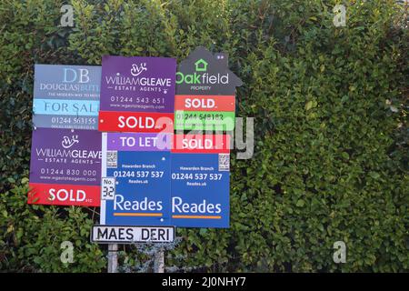 Sammlung von Immobilienmakler-Tafeln über einem Straßenschild Stockfoto