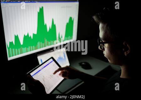 Analysten von Krypto-Händlern, die auf Computerbildschirms blicken und Finanzdaten auf dem pc betrachten Stockfoto
