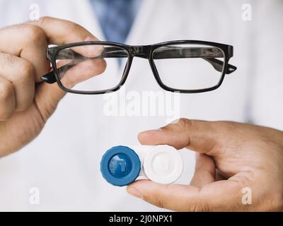 Männlicher Arzt zeigt Paar schwarze Brille Kontaktlinse. Hohe Qualität und Auflösung schönes Fotokonzept Stockfoto