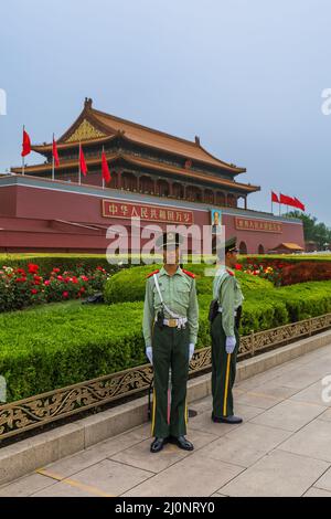 Peking, China - 16. Mai 2018: Polizist in der Nähe des Tse Tung Tiananmen-Tores von Mao im Palast der Verbotenen Stadt Gugong. Chinesische Sprüche zu GA Stockfoto