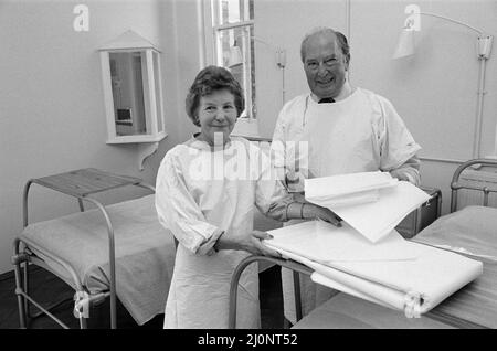 Das Catherine-de-Barnes Isolation Hospital, das sich ständig im Stand befindet, um Pocken zu behandeln. Sie nahmen Patienten zuletzt 1978 während des Pockenausbruchs an der Universität Birmingham auf. Im Bild: Herr Leslie Harris und seine Frau Dorothy sind seit 16 Jahren Hausmeister im Krankenhaus. Zu ihren Aufgaben gehört es, dass die Betten wie diese, die von der angrenzenden Pflegestation aus durch das Beobachtungsfenster gesehen werden können, immer bereit gestellt werden. Catherine-de-Barnes, Solihull. 3.. August 1983. Stockfoto