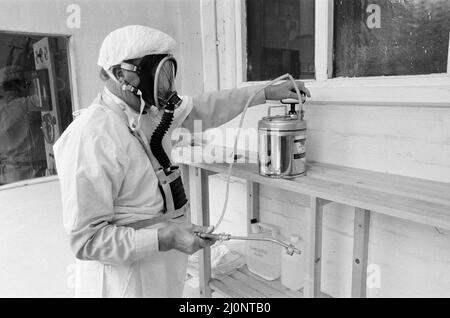 Das Catherine-de-Barnes Isolation Hospital, das sich ständig im Stand befindet, um Pocken zu behandeln. Sie nahmen Patienten zuletzt 1978 während des Pockenausbruchs an der Universität Birmingham auf. Im Bild testet der Hausmeister Leslie Harris mit einem Schutzanzug und einer Luftmaske die Begasungsausrüstung im speziellen Raucherraum des Krankenhauses. Catherine-de-Barnes, Solihull. 3.. August 1983. Stockfoto