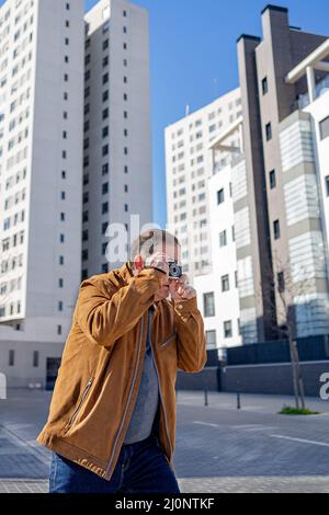 Nahaufnahme eines älteren Mannes, der mit einer alten Filmkamera in der Stadt fotografiert Stockfoto