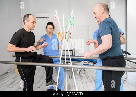 Gruppe von Menschen mit Behinderung Ausübung in der Rehabilitationsklinik. Stockfoto