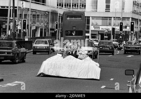 Patricia Hodge wird als Fernsehreporterin Jemima Shore in der neuen Serie "Jemima Shore Enforschungen" von Thames Television zu sehen sein. Im Bild kommt der Verkehr in Londons geschäftigen Tottenham Court Road zum Stillstand, als Patricia Hodge mit zwei der Darsteller der Serie, Larry Lamb und Malcolm Stoddard, ins Bett geht. 5.. Juni 1983. Stockfoto