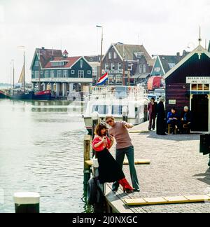 Vintage Netherlands 1970s, ein paar Touristen mittleren Alters, die Fotos machen, Marken Harbour, Waterland, Nordholland, Europa, Stockfoto