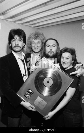 Midland-Popstars Slade haben £385 aufgesetzt, als sie auf dem Saturday Starship von Central TV auftraten und eine goldene Disc-Kopie von Slades Smash Hits versteigert, als sie den äthiopischen Hungeraufruf unterstützt haben. Slades Dave Hill und Noddy Holder sind mit Fan Frances Tucker aus Rushden abgebildet. 1.. Dezember 1984. Stockfoto