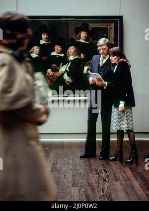 Vintage Amsterdam 1970s, stilvolles Paar mittleren Alters besucht das Rijksmuseum, sechs Regenten Gemälde von Ferdinand Bol 1657, Holland, Niederlande, Europa, Stockfoto