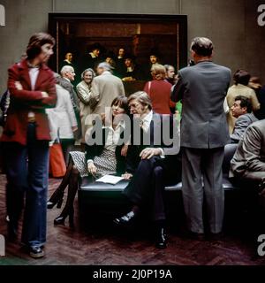 Vintage Amsterdam 1970s, stilvolles Paar mittleren Alters besucht das Rijksmuseum, die Sampling Beamten Gemälde von Rembrandt, Holland, Niederlande, Europa, Stockfoto