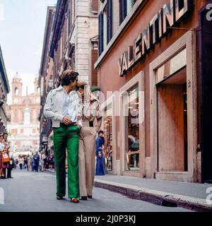 Vintage Rome 1970s, stilvolles Paar beim Spaziergang durch das Modegeschäft Valentino, die Einkaufsstraße Via dei Condotti, Italien, Europa, Stockfoto