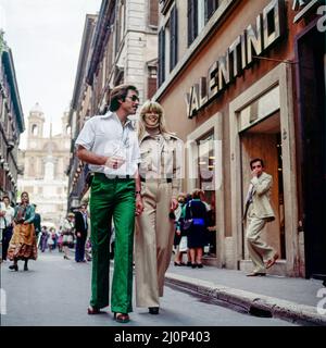 Vintage Rome 1970s, stilvolles Paar beim Spaziergang durch das Modegeschäft Valentino, die Einkaufsstraße Via dei Condotti, Italien, Europa, Stockfoto