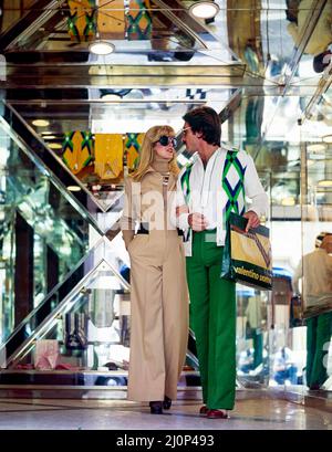 Vintage Rome 1970s, stilvolles Paar, das vom Modegeschäft Valentino Uomo, der Einkaufsstraße Via dei Condotti, Italien, Europa, Stockfoto