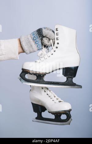 Frau mit der Hand der weißen Schlittschuhe. Hohe Qualität und Auflösung schönes Fotokonzept Stockfoto