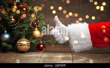 Die Hand des Weihnachtsmanns zeigt die Daumen nach oben. Stockfoto