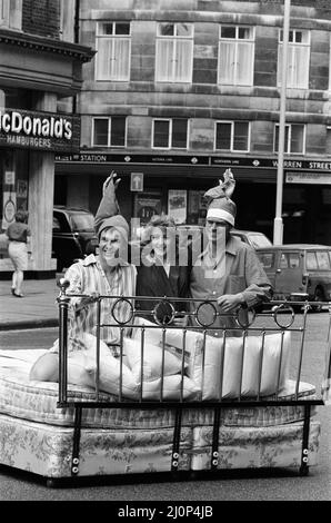 Patricia Hodge wird als Fernsehreporterin Jemima Shore in der neuen Serie "Jemima Shore Enforschungen" von Thames Television zu sehen sein. Im Bild kommt der Verkehr in Londons geschäftigen Tottenham Court Road zum Stillstand, als Patricia Hodge mit zwei der Darsteller der Serie, Larry Lamb und Malcolm Stoddard, ins Bett geht. 5.. Juni 1983. Stockfoto