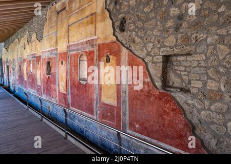 Das Haus von Julia Felix (Praedia di Giulia Felice) im Inneren der antiken Stadt Pompeji in Pompei, Italien. Wand des Ambulatoriums mit roter Farbe verziert Stockfoto