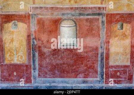 Das Haus von Julia Felix (Praedia di Giulia Felice) im Inneren der antiken Stadt Pompeji in Pompei, Italien. Rot und gelb bemalte Wand mit quadratischer Form A Stockfoto