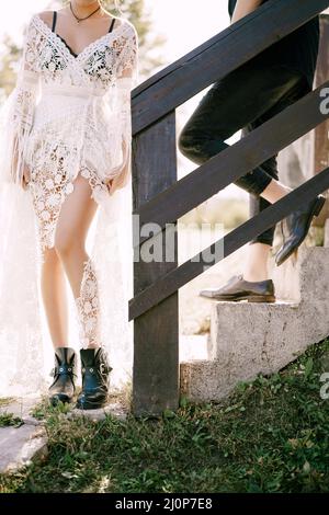 Mann und Frau stehen auf einer Steintreppe in der Nähe von Holzgeländer Stockfoto