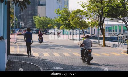 Maledivische Einheimische fahren auf den Bikes auf den Straßen von Male City Stockfoto