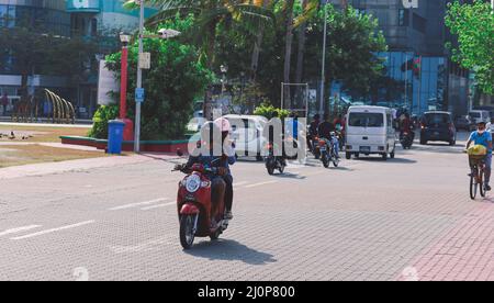 Maledivische Einheimische fahren auf den Bikes auf den Straßen von Male City Stockfoto