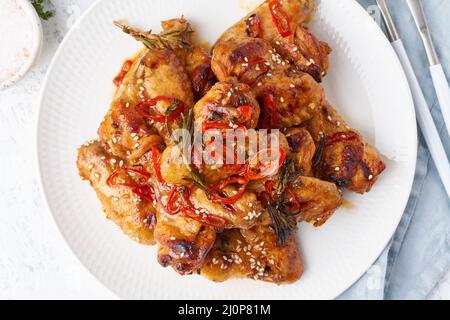 Grillhähnchenflügel. Slow Herd süß und würzig. Im Ofen gebackene marinierte Chiken auf dem Teller Stockfoto