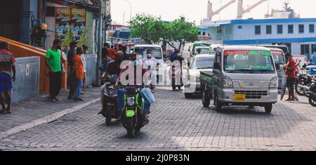 Maledivische Einheimische fahren auf den Bikes auf den Straßen von Male City Stockfoto