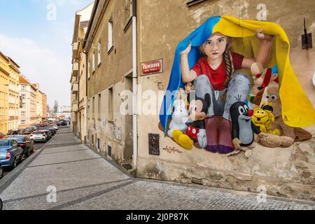 Ein Mädchen, das unter ukrainischer Flagge Schutz nimmt, Wandgemälde von ChemiS (tschechischer Künstler mit kasachischen Wurzeln, Dmitri Proshkin), Nusle, Prag, Tschechische republik Stockfoto