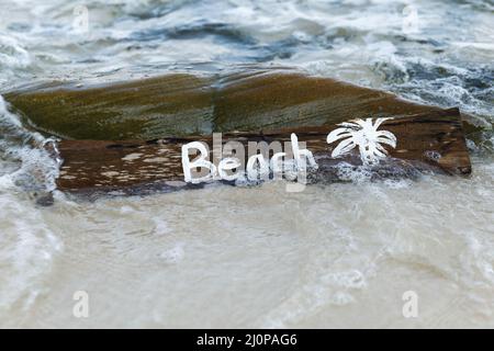 Holzschild mit Schriftzug am Strand Stockfoto