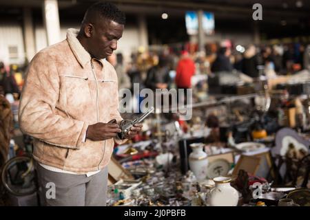 Afroamerikanischer Mann wählt Antiquitäten auf dem Flohmarkt Stockfoto