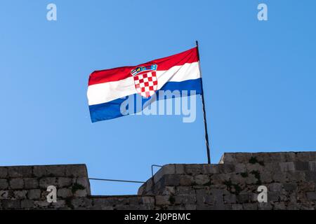 Nahaufnahme der kroatischen Flagge bei starkem Wind unter blauem Himmel Stockfoto