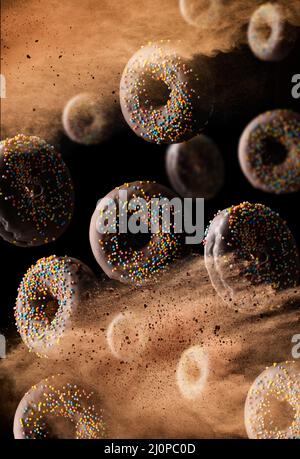 In einer Wolke aus braunem Kakao auf schwarzem Hintergrund schweben runde Schokoladendonuts mit bunten Zuckerstreuseln. Pulver fliegt Stockfoto