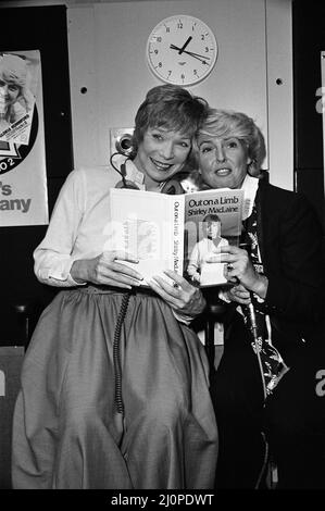 Shirley MacLaine bei der BBC wird mit ihrem neuen Buch „Out on a Limb“ im Gloria Hunniford-Programm auftreten. Shirley und Gloria posieren mit dem Buch. 4.. Oktober 1983. Stockfoto