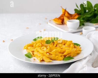 Kürbis-Pasta-Penne mit dicker cremiger Sauce aus gebackenem Kürbis und Parmesan, Seitenansicht Stockfoto