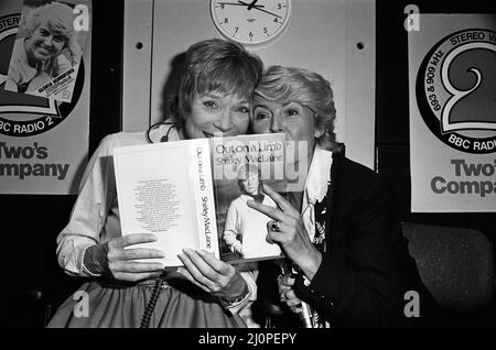 Shirley MacLaine bei der BBC wird mit ihrem neuen Buch „Out on a Limb“ im Gloria Hunniford-Programm auftreten. Shirley und Gloria posieren mit dem Buch. 4.. Oktober 1983. Stockfoto