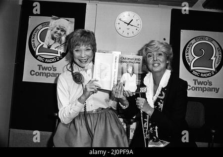 Shirley MacLaine bei der BBC wird mit ihrem neuen Buch „Out on a Limb“ im Gloria Hunniford-Programm auftreten. Shirley und Gloria posieren mit dem Buch. 4.. Oktober 1983. Stockfoto