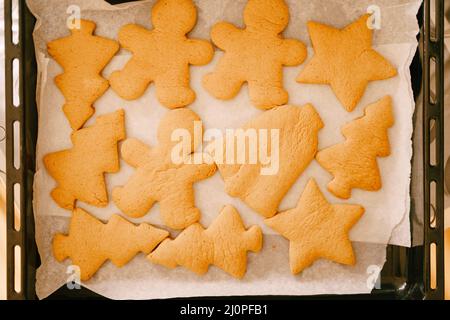 Frisch gekochte Lebkuchen auf einem Backblech aus dem Ofen, Nahaufnahme von verschiedenen Formen von Cookies. Stockfoto
