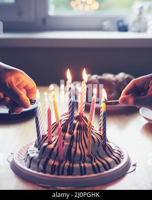 Bunte Geburtstagskuchen mit mit Händen brennenden neunzehn Kerzen Home Party Stockfoto