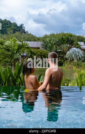 Ehepaar Mann und Frau im Schwimmbad in Asien, Männer und asiatische Frau im Pool in Thailand am See in den Bergen Stockfoto