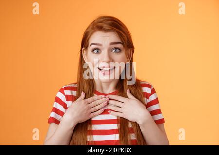 Rotschopf nettes Mädchen erhalten angenehme Nachrichten. Entzückt glücklich Ingwer Frau drücken Hände Brust erstaunt, schauen Kamera entzückt Stockfoto