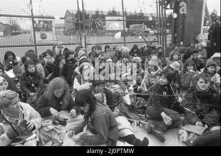 70.000 Demonstranten treffen sich zum "Women's Peace Camp" in Greenham Common und dem Atomwaffenstützpunkt in Aldermarston, um eine 14 Meilen lange Menschenkette zwischen den beiden Stützpunkten zu schaffen, um gegen die Entscheidung, amerikanische Marschflugkörper bei Greenham Common zu stationieren und die Verbreitung von Atomwaffen zu protestieren. Unser Bild zeigt: Frauen aus dem Friedenslager blockieren das Gelbe Tor in den RAF Greenham Common 1.. April 1983 Stockfoto
