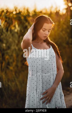 Junge schöne Frau in weißem Kleid im Maisfeld. Stockfoto