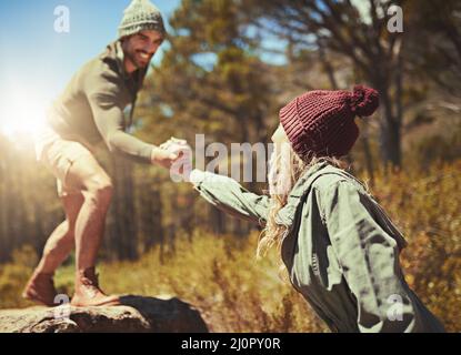 Und ihr eine Hand geben. Kurzer Shot eines jungen Paares beim Wandern. Stockfoto