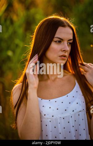 Junge schöne Frau in weißem Kleid im Maisfeld. Stockfoto